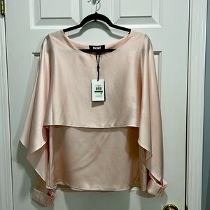 blouse provides a dramatic silhouette with a beautifully draped cape detail.